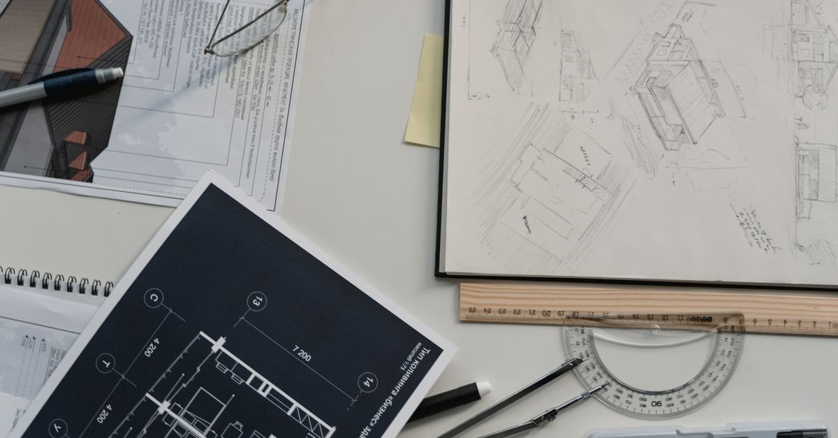 Plans architecturaux détaillés posés sur un bureau avec instruments de mesure