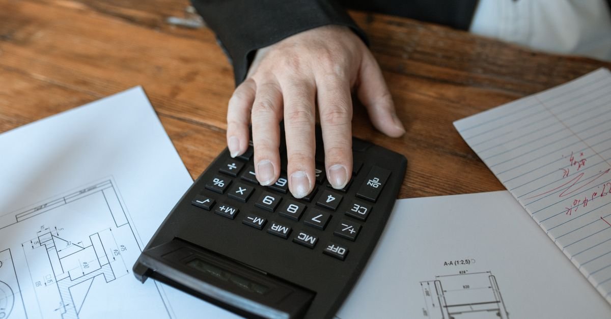 Personne utilisant une calculatrice pour estimer un budget de travaux