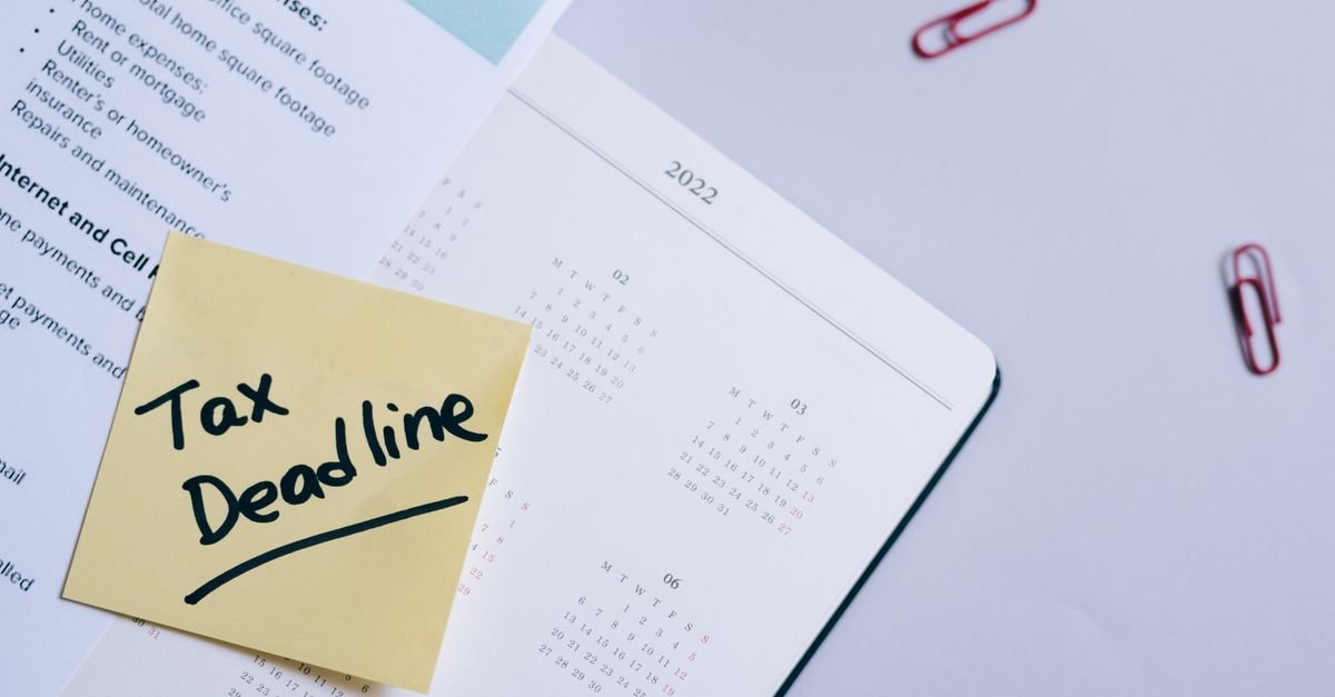 Note adhésive posée sur un agenda ouvert, avec un stylo