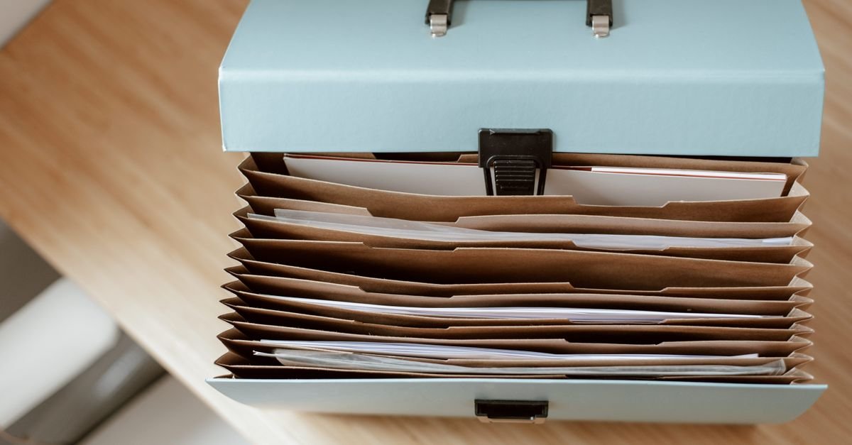 Porte-documents ouvert contenant des dossiers papier posé sur une table