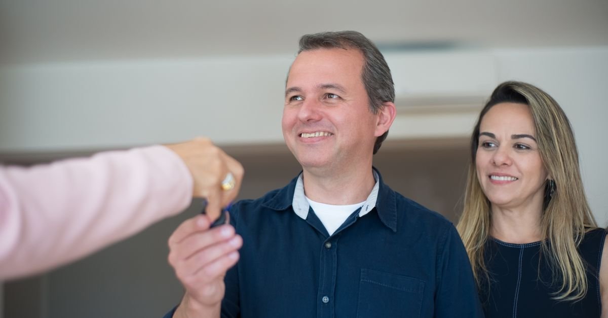 Remise des clés d'une maison neuve à un couple par un professionnel