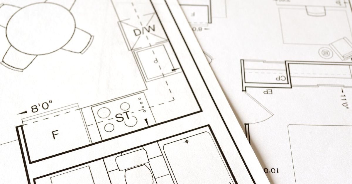 Plans architecturaux et esquisses de maison posés sur une table de travail